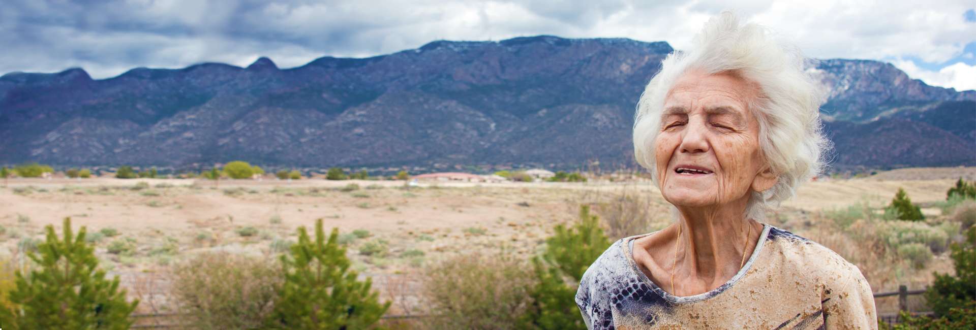 Older woman in the desert enjoying the breeze.